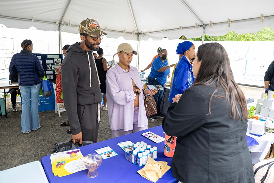 Expectant couple talks with volunteer.