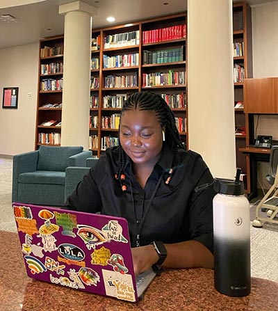 Guyline Malala works on a laptop.