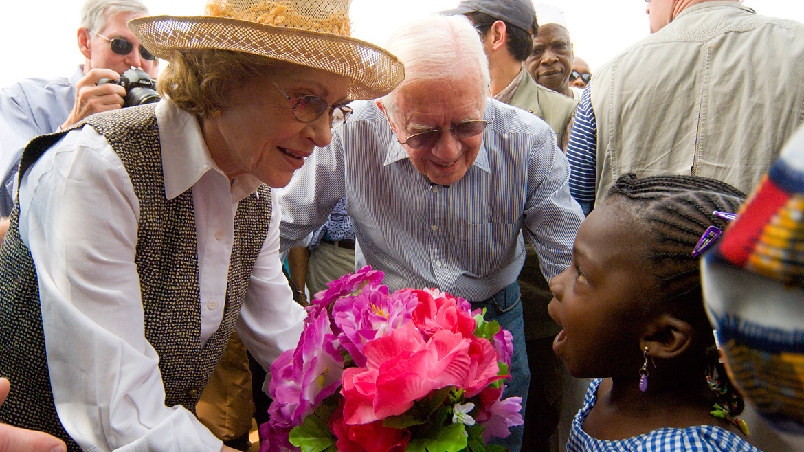 Mrs. Carter gives a girl flowers.