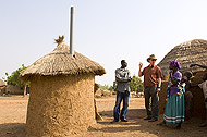 Photo of Dr. Paul Emerson, Nazeed Fusheini, and a Ghanain woman discussing her family's latrine. 