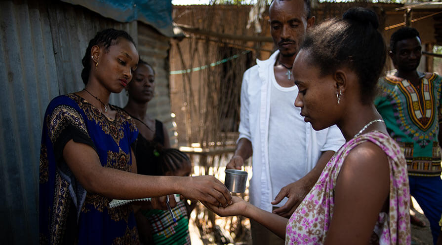 River blindness most often occurs in rural areas but also can be found in urban settings under certain circumstances. CDD Tigist Gebremeskel, left, administers Mectizan to a resident of Gambella Town’s densely populated Kebele 5 neighborhood. The man holding the cup of water to wash down the tablets is CDD Tesema Desalegn. 